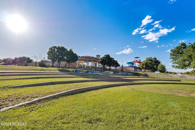 view of community with fence and a yard