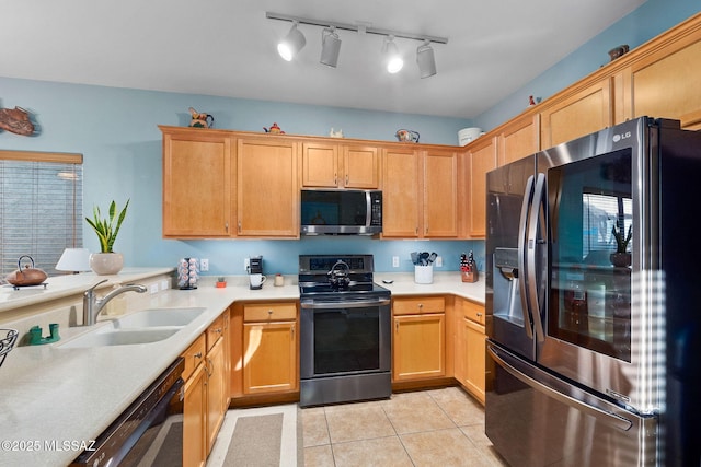 kitchen with light countertops, stainless steel appliances, light tile patterned floors, and a sink