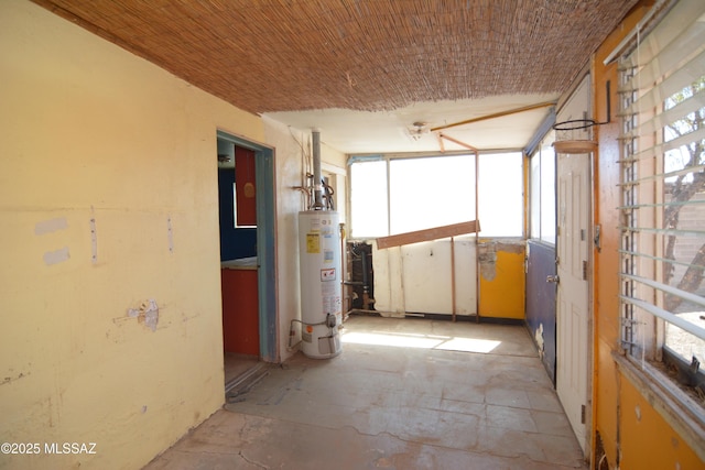 corridor featuring water heater and plenty of natural light