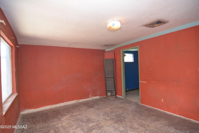 empty room featuring baseboards and visible vents