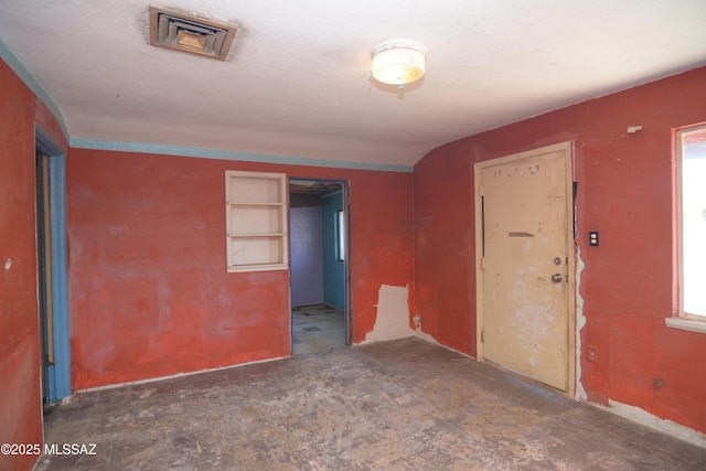 unfurnished room featuring visible vents
