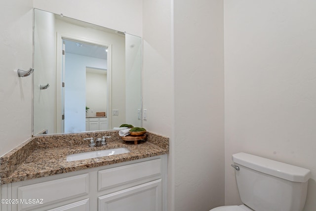 half bathroom with vanity and toilet