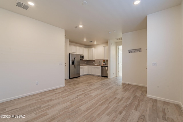 kitchen featuring white cabinets, appliances with stainless steel finishes, visible vents, and light wood-style floors