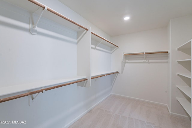empty room featuring baseboards, light carpet, and recessed lighting