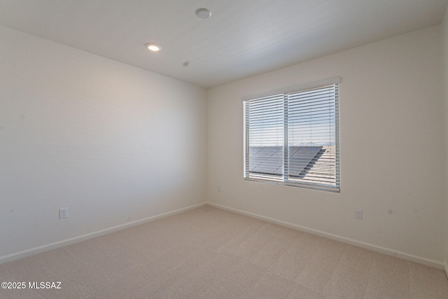 empty room featuring recessed lighting, baseboards, and light carpet