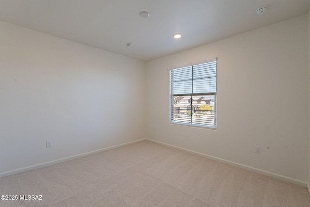 empty room featuring baseboards, light carpet, and recessed lighting
