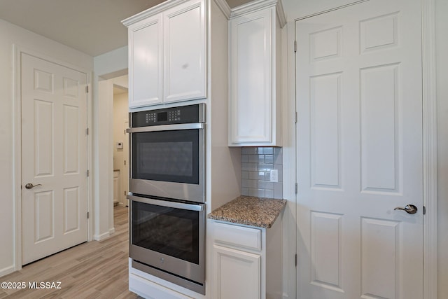 kitchen with visible vents, light wood-style floors, white cabinetry, a sink, and appliances with stainless steel finishes