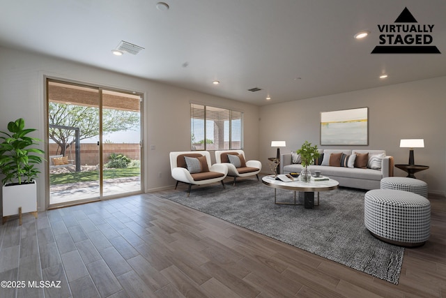 living room with baseboards, recessed lighting, wood finished floors, and visible vents