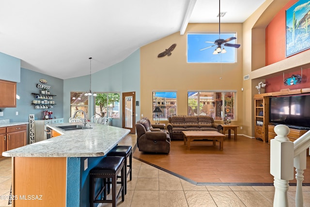 9949 N Blue Crossing Way, Tucson, AZ 85743 - kitchen featuring a sink, a ceiling fan, high vaulted ceiling, plenty of natural light, and a breakfast bar area