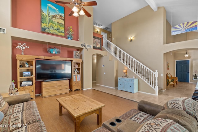 9949 N Blue Crossing Way, Tucson, AZ 85743 - living room featuring arched walkways, high vaulted ceiling, stairway, a ceiling fan, and beamed ceiling