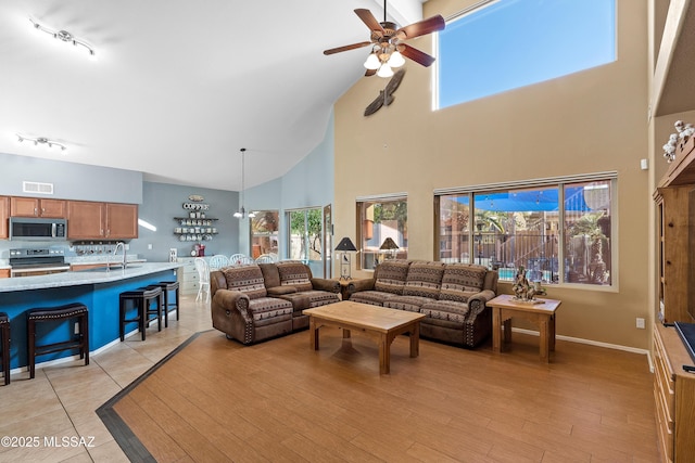 9949 N Blue Crossing Way, Tucson, AZ 85743 - living area featuring high vaulted ceiling, a ceiling fan, and light wood-type flooring