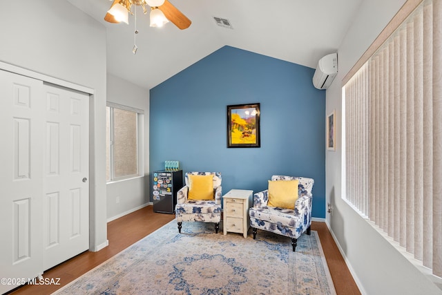 9949 N Blue Crossing Way, Tucson, AZ 85743 - sitting room featuring a ceiling fan, wood finished floors, vaulted ceiling, a wall mounted air conditioner, and baseboards