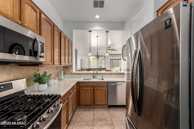 5884 S Azure Vista Way, Green Valley, AZ 85622 - kitchen featuring appliances with stainless steel finishes, a sink, brown cabinetry, light countertops, and ceiling fan
