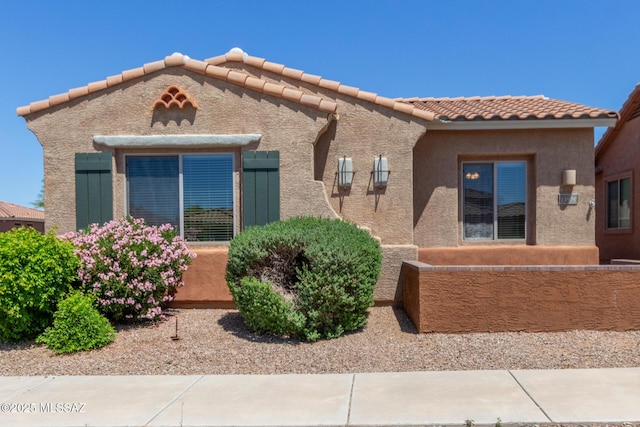 mediterranean / spanish-style home with stucco siding and a tiled roof