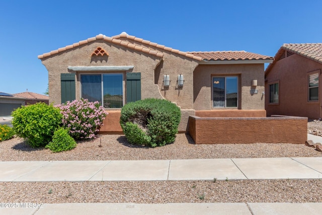 mediterranean / spanish-style home with stucco siding and a tile roof