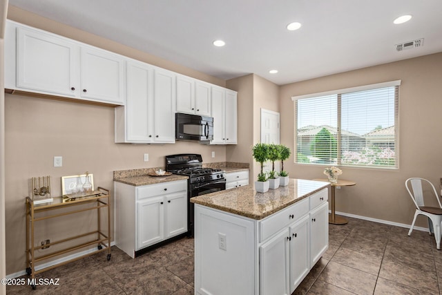 kitchen with visible vents, white cabinets, light stone counters, and black appliances