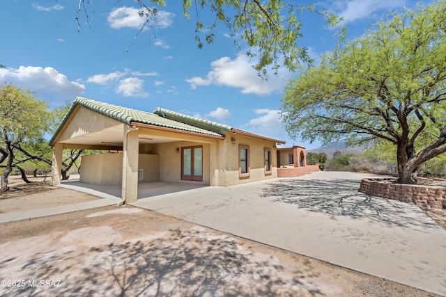 12471 E Speedway Blvd, Tucson, AZ 85748 - back of house with a tile roof, stucco siding, a patio, an attached carport, and french doors