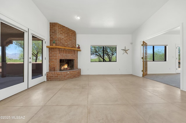 12471 E Speedway Blvd, Tucson, AZ 85748 - unfurnished living room with healthy amount of natural light, french doors, concrete floors, and a fireplace