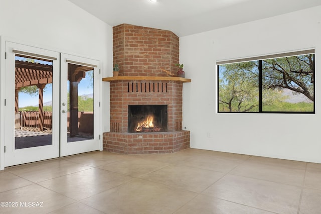 12471 E Speedway Blvd, Tucson, AZ 85748 - unfurnished living room with vaulted ceiling, french doors, concrete flooring, and a brick fireplace