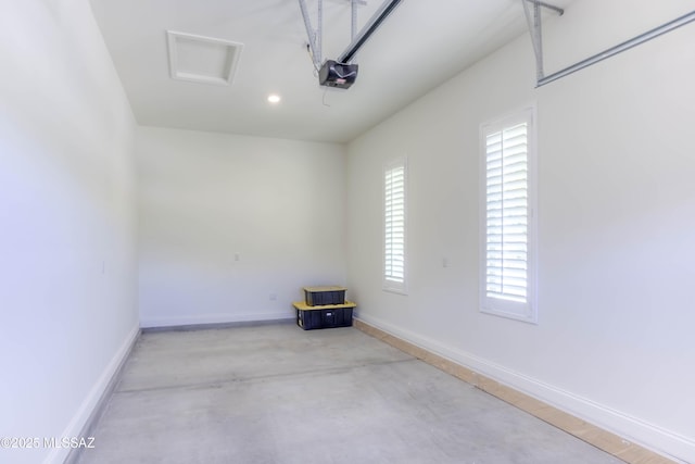 garage with baseboards, a garage door opener, and recessed lighting