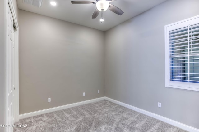 carpeted spare room featuring visible vents, baseboards, and ceiling fan