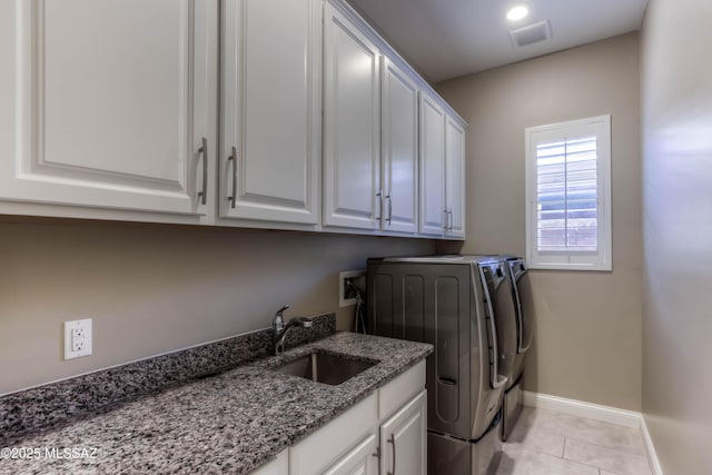 washroom featuring a sink, cabinet space, visible vents, baseboards, and light tile patterned flooring