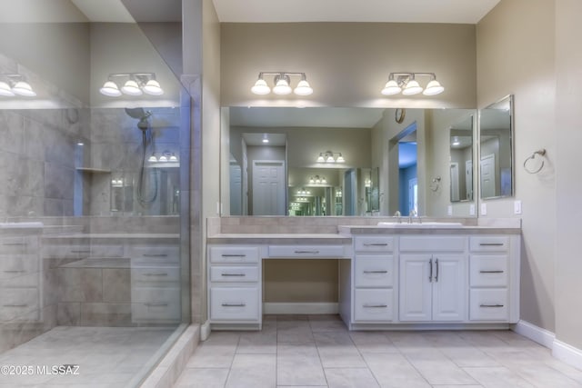 bathroom featuring vanity, baseboards, tiled shower, and tile patterned flooring