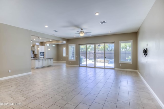 unfurnished living room with visible vents, recessed lighting, a ceiling fan, light tile patterned floors, and baseboards