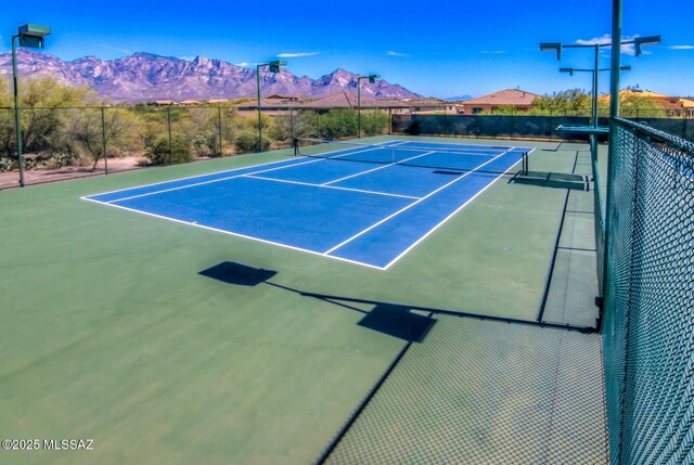 view of tennis court featuring fence and a mountain view