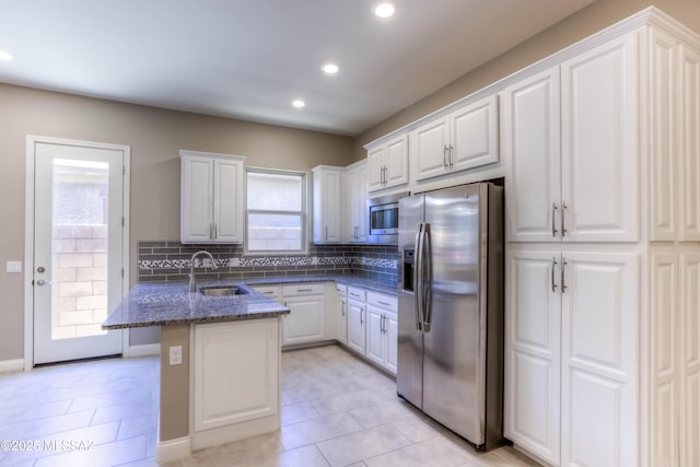 kitchen featuring white cabinets, backsplash, stainless steel appliances, and a sink
