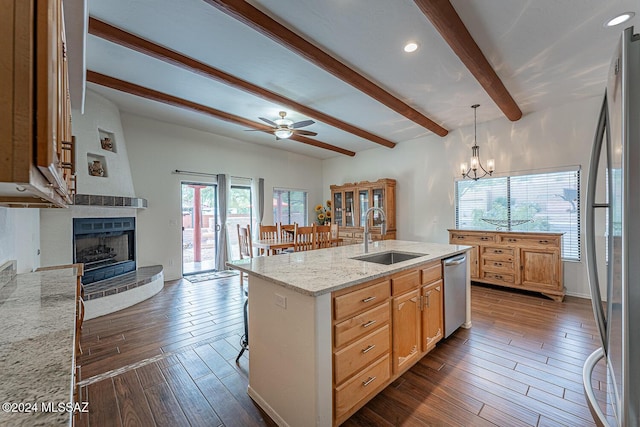 kitchen with appliances with stainless steel finishes, beam ceiling, a sink, a fireplace, and dark wood finished floors
