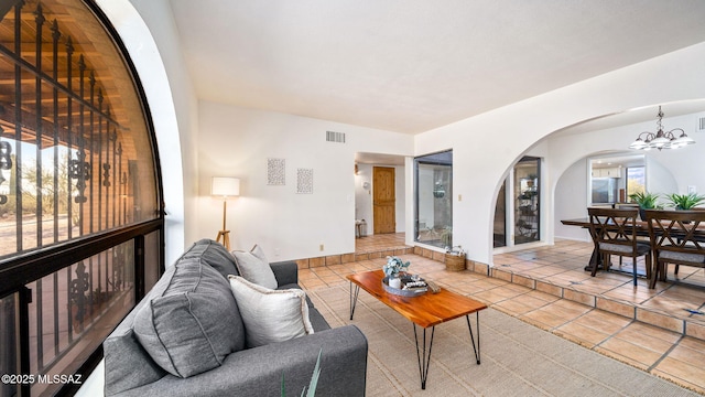 900 N Camino Del Codorniz, Tucson, AZ 85749 - living area with tile patterned flooring, a chandelier, arched walkways, and baseboards