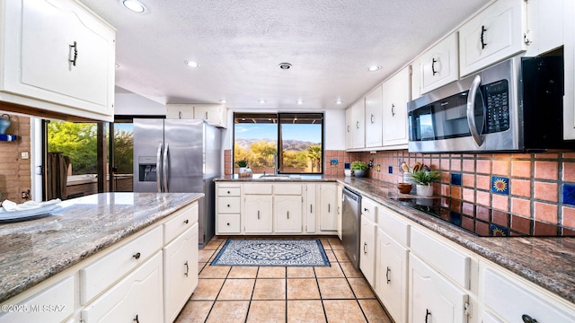 900 N Camino Del Codorniz, Tucson, AZ 85749 - kitchen with stainless steel appliances, recessed lighting, decorative backsplash, white cabinets, and a sink