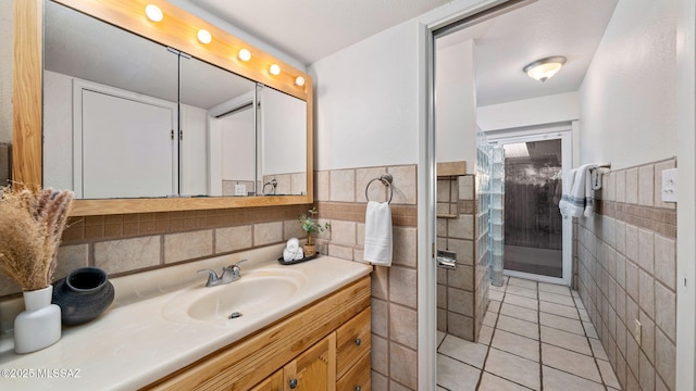 900 N Camino Del Codorniz, Tucson, AZ 85749 - bathroom featuring tile walls, vanity, tile patterned floors, and wainscoting