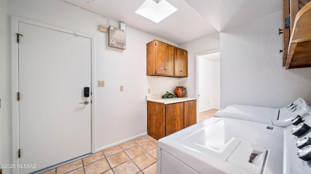 900 N Camino Del Codorniz, Tucson, AZ 85749 - washroom with cabinet space, washing machine and dryer, a skylight, light tile patterned floors, and baseboards