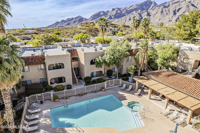 pool featuring fence, a mountain view, and a patio