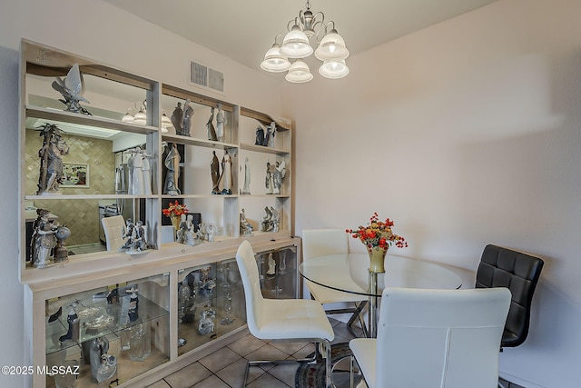 dining space featuring tile patterned flooring, a notable chandelier, and visible vents