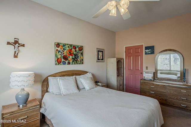 bedroom featuring ceiling fan, vaulted ceiling, and dark colored carpet