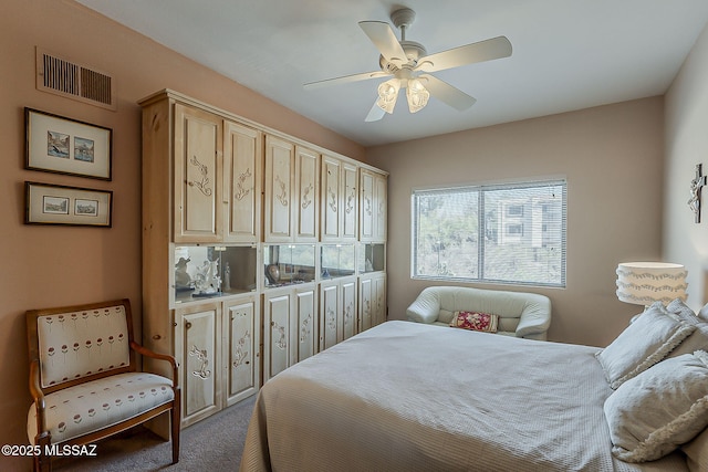 carpeted bedroom with ceiling fan and visible vents