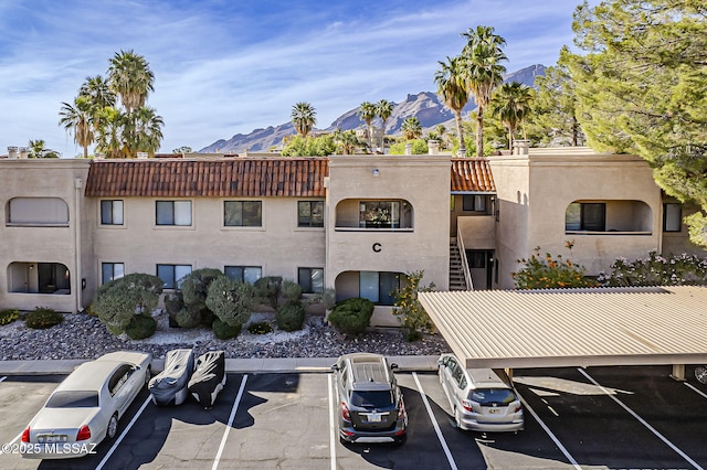 view of property with uncovered parking and a mountain view