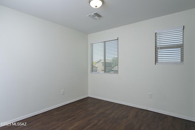 1139 E Madera Grove Ln, Sahuarita, AZ 85629 - empty room with visible vents, baseboards, and dark wood-style floors