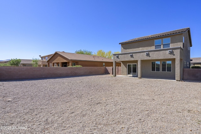 back of property featuring a fenced backyard, a patio, and stucco siding
