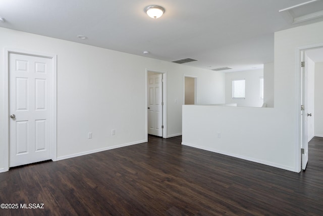 1139 E Madera Grove Ln, Sahuarita, AZ 85629 - empty room featuring visible vents, attic access, dark wood-style flooring, and baseboards