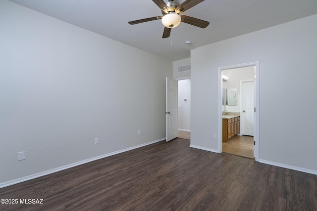 493 E Placita Nodo, Sahuarita, AZ 85629 - unfurnished bedroom featuring baseboards, visible vents, ensuite bathroom, and dark wood-type flooring