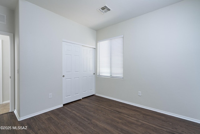 493 E Placita Nodo, Sahuarita, AZ 85629 - unfurnished bedroom with baseboards, visible vents, dark wood finished floors, and a closet