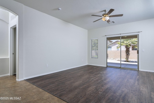 493 E Placita Nodo, Sahuarita, AZ 85629 - unfurnished room with a ceiling fan, visible vents, arched walkways, baseboards, and dark wood-type flooring