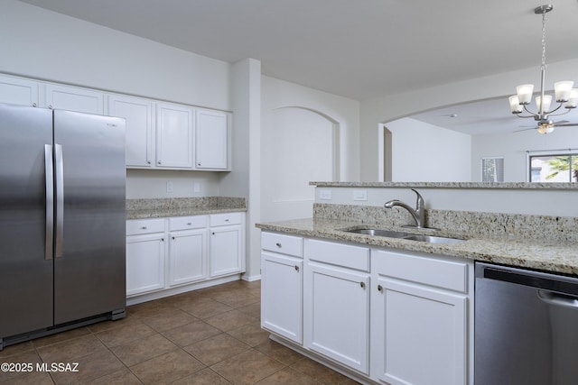 493 E Placita Nodo, Sahuarita, AZ 85629 - kitchen with white cabinets, an inviting chandelier, a sink, stainless steel appliances, and dark tile patterned floors