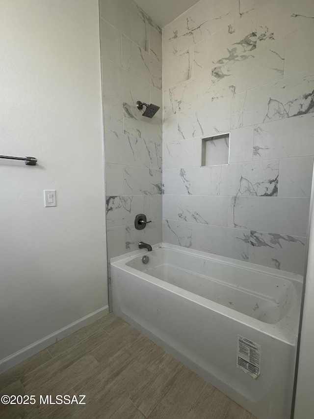 bathroom featuring baseboards and shower / tub combination