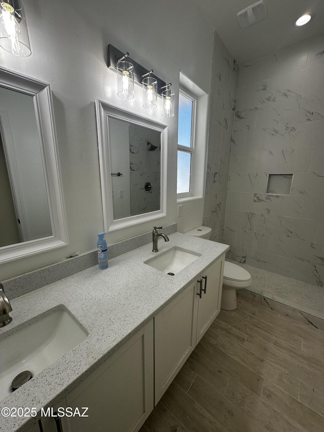 bathroom featuring visible vents, a sink, a stall shower, and toilet