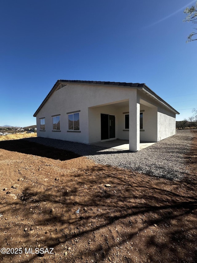 back of property featuring a patio and stucco siding